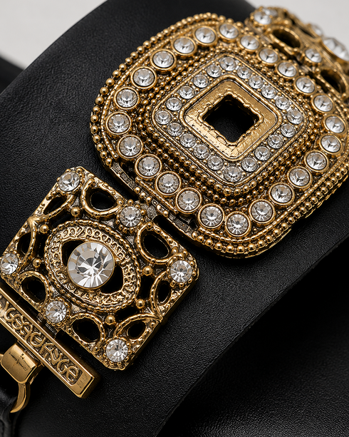 Close up of Aurista black flat sandals highlighting intricate antique gold embellishments and premium craftsmanship.