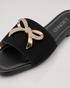 Close up of Aveen black flat sandals featuring embellished bow detail