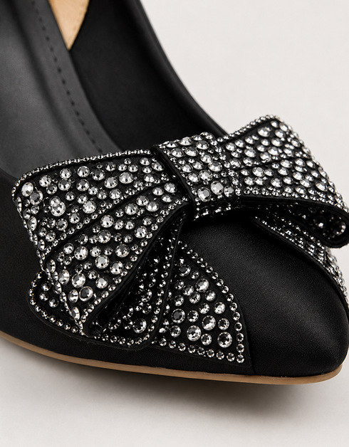 Close up of black pointed toe heels with sparkling rhinestone bow embellishment