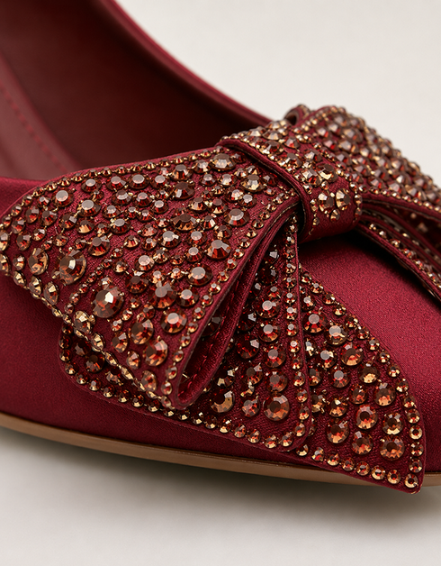 Close up of maroon pointed toe heels with sparkling crystal bow embellishment