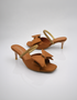 Pair of brown bow kitten heel sandals with elegant shimmer strap and open toe design.