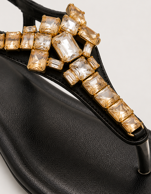 Close-up of black T-strap sandals featuring gold crystal rhinestone embellishment, premium quality women sandals, fancy flat sandals for parties and casual wear Pakistan
