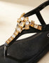 Close-up of black T-strap sandals featuring gold crystal rhinestone embellishment, premium quality women sandals, fancy flat sandals for parties and casual wear Pakistan