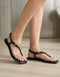 Women wearing black crystal embellished T-strap sandals with gold rhinestone detailing, open toe flat sandals for summer, comfortable ladies footwear Pakistan, stylish casual and formal sandals