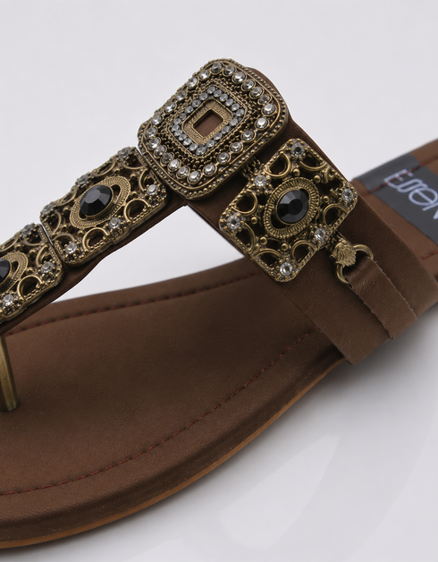 Close-up of antique gold buckle and embellishment on Kolhapuri flat sandal