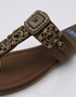Close-up of antique gold buckle and embellishment on Kolhapuri flat sandal