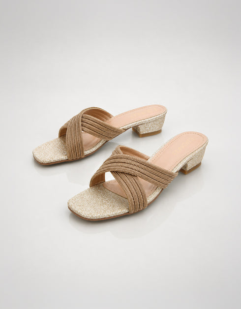 Woman wearing gold embellished low block heel slippers for weddings and festive occasions.