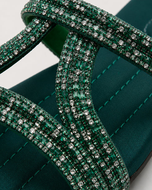 Close up of teal embellished flat sandals highlighting the shimmering strap detailing and premium craftsmanship.