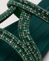 Close up of teal embellished flat sandals highlighting the shimmering strap detailing and premium craftsmanship.