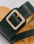 Close up of green buckle flat sandals highlighting the decorative buckle and premium craftsmanship.