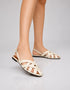 Woman wearing cream criss cross closed toe sandals with woven straps and slingback design, fashionable flat sandals for women, comfortable summer footwear Pakistan for casual and semi-formal wear