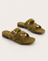Pair of olive cross strap flat sandals with statement buckle and soft padded sole.