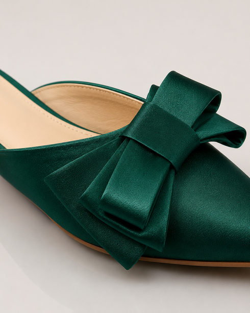 Close up of statement bow on green pointed toe flat mules