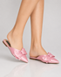 Model wearing pink pointed toe flat mules with oversized bow in Pakistan