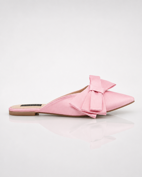 Side view of pink pointed toe flat mules with statement bow