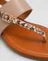 Detailed view of textured strap on beige women's flat sandals