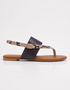 Side profile of brown flat sandals with slip on design