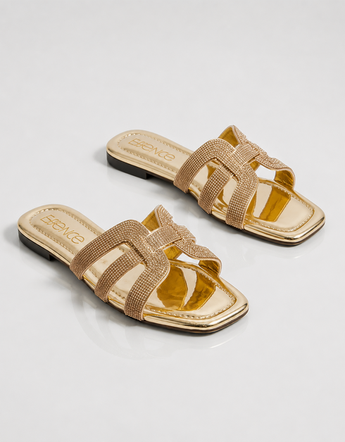 Pair of gold shimmer flat sandals with elegant multi strap design and cushioned sole.
