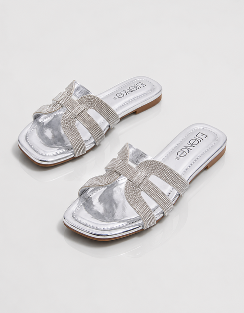 Pair of silver shimmer flat sandals with elegant multi strap design and cushioned footbed.