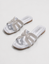 Pair of silver shimmer flat sandals with elegant multi strap design and cushioned footbed.