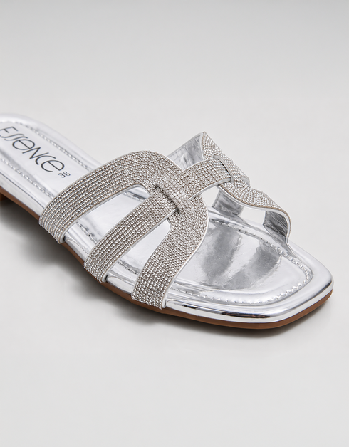Side view of silver shimmer flat sandals featuring lightweight slip on construction.