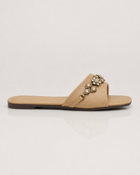 Side view of beige crystal embellished flat sandals featuring a lightweight slip on silhouette.