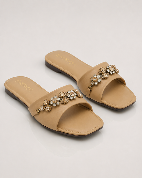 Pair of beige crystal embellished flat sandals with soft padded sole and elegant design.