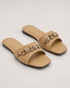 Pair of beige crystal embellished flat sandals with soft padded sole and elegant design.