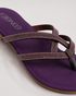 Close-up of shimmering straps on purple flat sandals