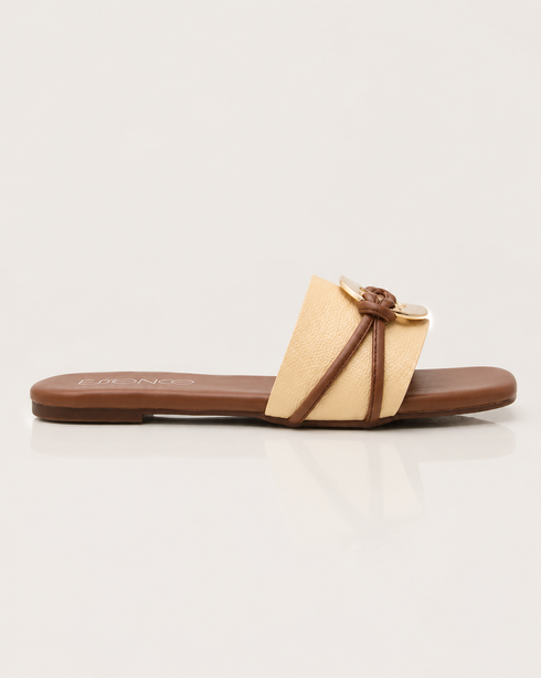 Side view of beige buckle flat sandals featuring a textured strap and lightweight slip on design.