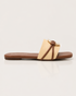 Side view of beige buckle flat sandals featuring a textured strap and lightweight slip on design.