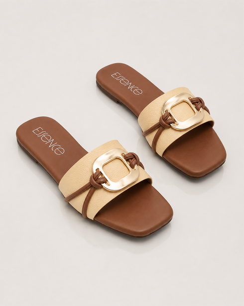 Pair of beige buckle flat sandals with oversized metallic buckle and padded comfort sole.