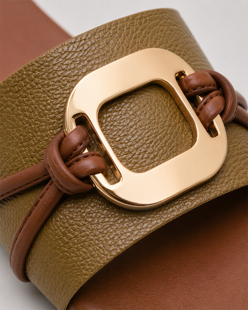 Close up of olive green buckle flat sandals showing textured strap and premium metallic buckle.