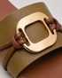 Close up of olive green buckle flat sandals showing textured strap and premium metallic buckle.