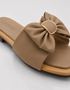 Detail Close up beige bow flat sandal with oversized bow detail and soft cushioned sole.