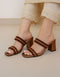 Brown block heel sandals for women featuring braided dual straps and a structured heel