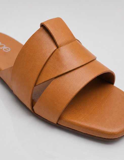 Close up of tan overlapping straps showcasing premium craftsmanship and smooth finish.