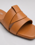 Close up of tan overlapping straps showcasing premium craftsmanship and smooth finish.