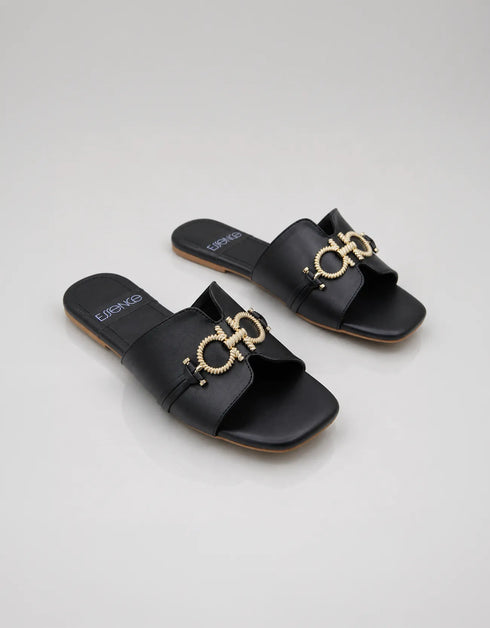 Pair of Nova Chic Comfort Flat Sandals in Black with premium synthetic material and elegant gold buckle detail.