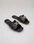 Pair of Nova Chic Comfort Flat Sandals in Black with premium synthetic material and elegant gold buckle detail.