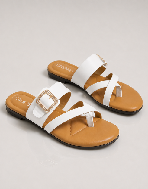 Side view of white buckle flat sandals featuring a lightweight slip on design and toe ring.