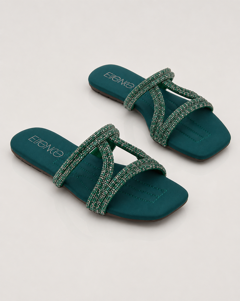 Pair of teal embellished flat sandals with shimmering straps and cushioned comfort.