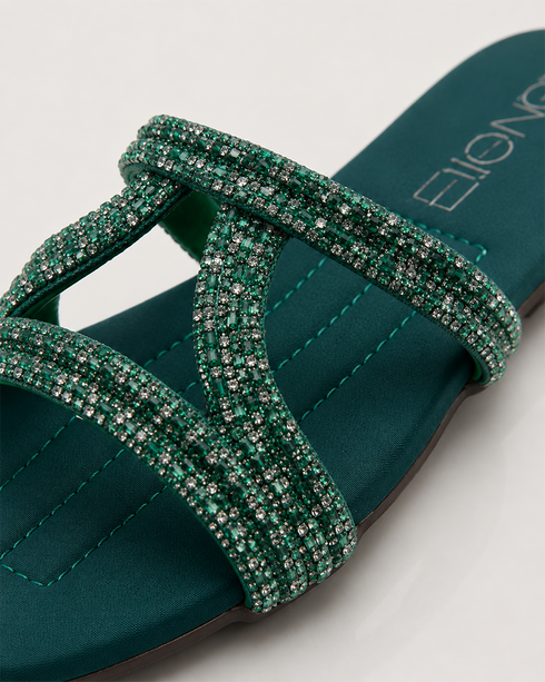 Close up of teal embellished flat sandals highlighting the shimmering strap detailing and premium craftsmanship.