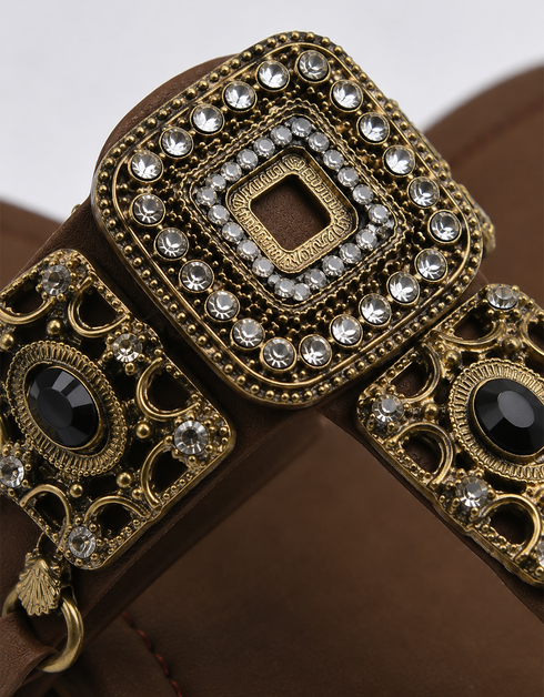 Close-up of antique gold buckle and embellishment on Kolhapuri flat sandal