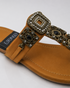 Close-up of antique gold buckle and embellishment on Mustard Kolhapuri flat sandal