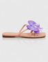 Side view of purple floral flat sandal with orchid detail and slim strap design