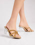 Auryn gold block heel sandals worn on feet showing rhinestone cross straps and transparent block heel by Essence by Rubina Pakistan
