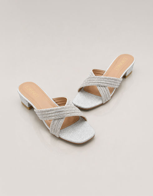 Pair of silver embellished cross strap low block heel slippers with shimmer finish.