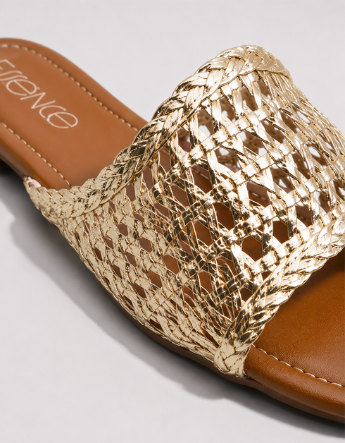Gold woven sandal with brown leather sole on a light gray background