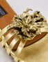 Close up of metallic flower embellishment on Imperial gold rexine flat sandals